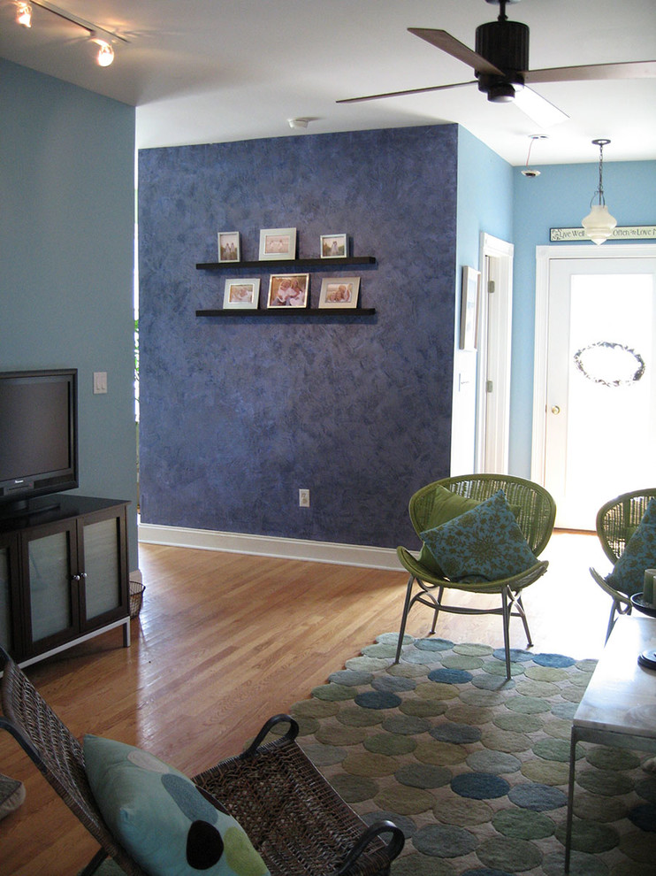 チャールストンにある低価格の中くらいなコンテンポラリースタイルのおしゃれなオープンリビング (青い壁、淡色無垢フローリング、据え置き型テレビ) の写真