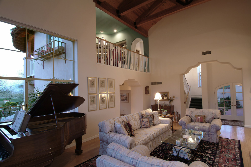 Immagine di un grande soggiorno mediterraneo stile loft con sala della musica, pareti beige, parquet chiaro e camino classico