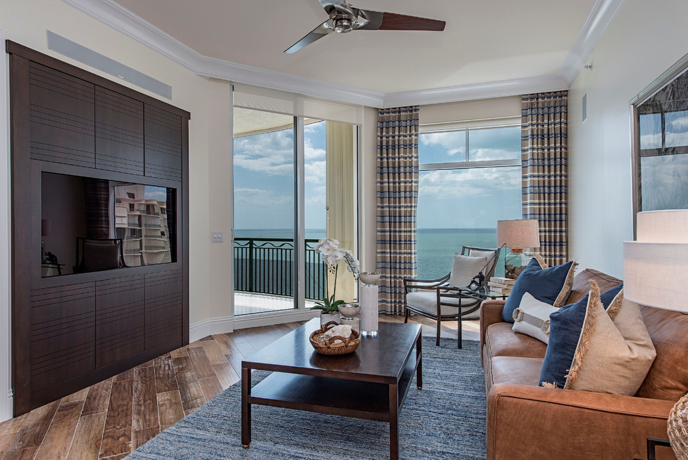 Design ideas for a large beach style enclosed games room in Miami with a game room, beige walls, light hardwood flooring and a built-in media unit.
