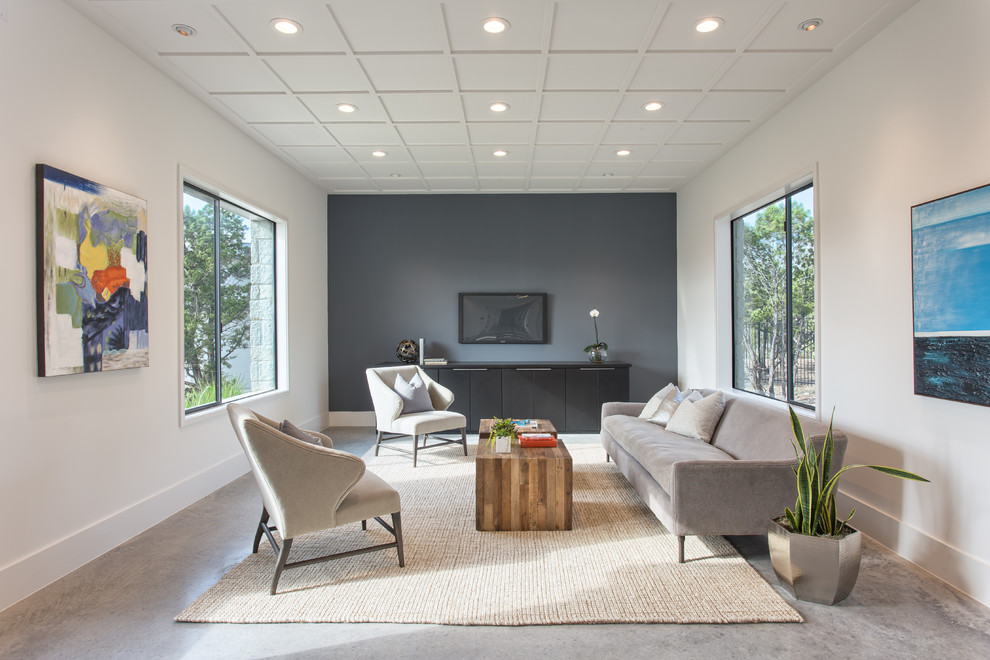 На фото: гостиная комната в современном стиле с телевизором на стене, белыми стенами и ковром на полу без камина