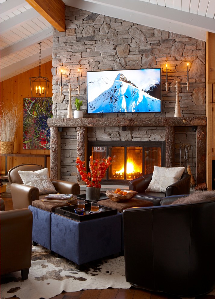 Пример оригинального дизайна: открытая гостиная комната среднего размера в стиле кантри с коричневыми стенами, паркетным полом среднего тона, стандартным камином, фасадом камина из камня, телевизором на стене и коричневым полом