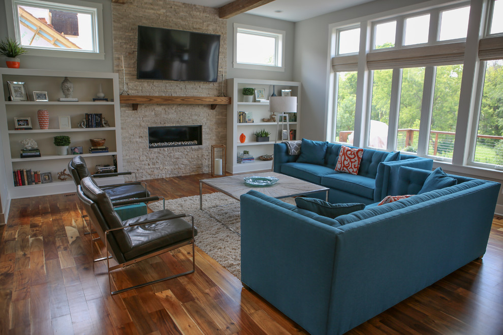 Großes, Offenes Stilmix Wohnzimmer mit hellem Holzboden, Kamin, Kaminumrandung aus Stein und TV-Wand in Chicago