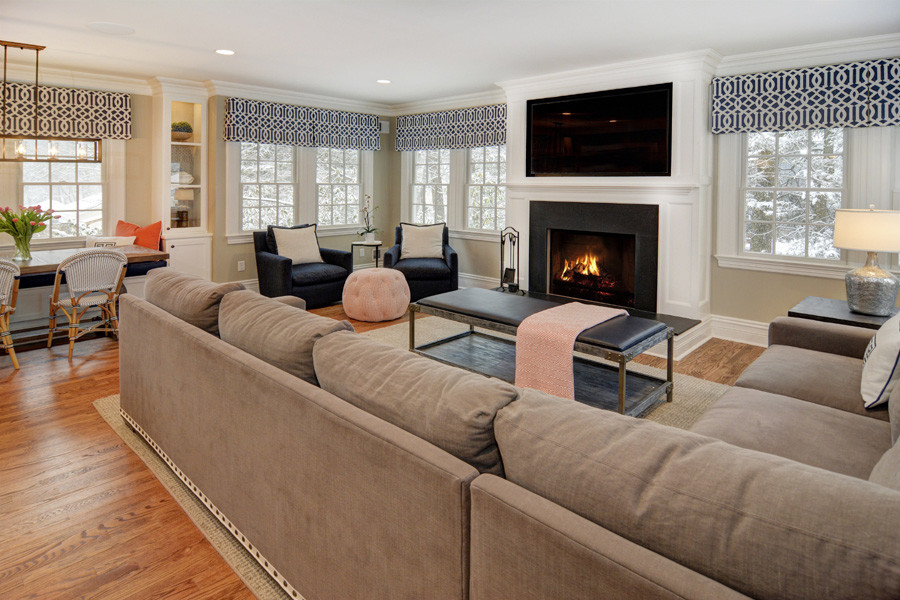 Large traditional open plan games room in Newark with beige walls, medium hardwood flooring, a standard fireplace, a wooden fireplace surround and a built-in media unit.