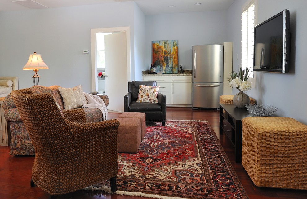 Ejemplo de sala de estar cerrada tradicional renovada de tamaño medio con paredes azules, suelo de madera en tonos medios y televisor colgado en la pared