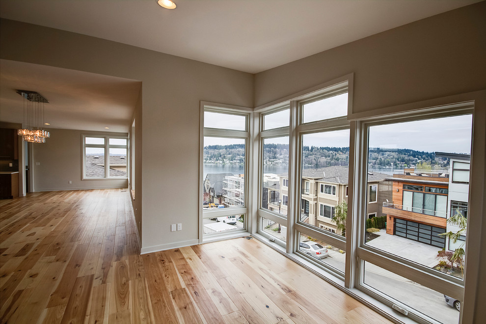 Large trendy open concept light wood floor and beige floor family room photo in Seattle with beige walls