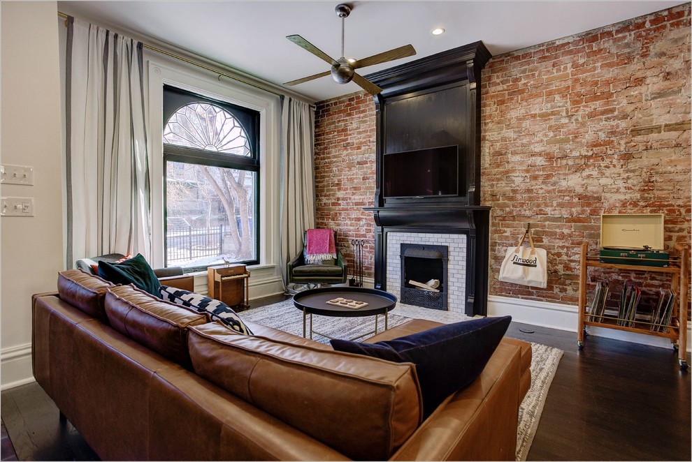 This is an example of a traditional open plan games room in Denver with beige walls, dark hardwood flooring, a standard fireplace, a tiled fireplace surround and a wall mounted tv.
