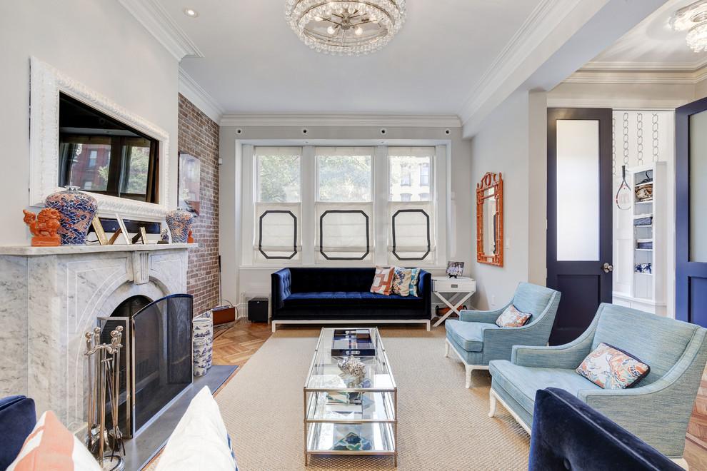 Foto de sala de estar abierta clásica con paredes grises, suelo de madera clara, todas las chimeneas y televisor colgado en la pared