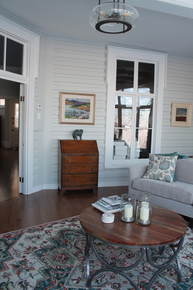 Cette photo montre une salle de séjour victorienne de taille moyenne et fermée avec un mur bleu et un sol en bois brun.