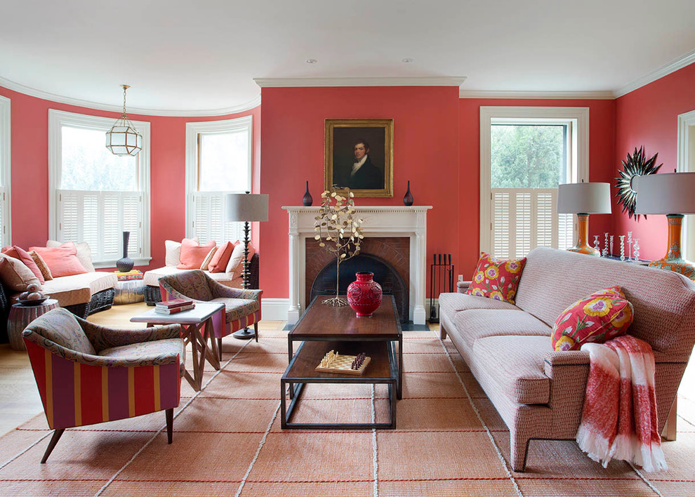 Exemple d'une grande salle de séjour éclectique ouverte avec un mur rouge, un sol en bois brun, une cheminée standard et un manteau de cheminée en bois.