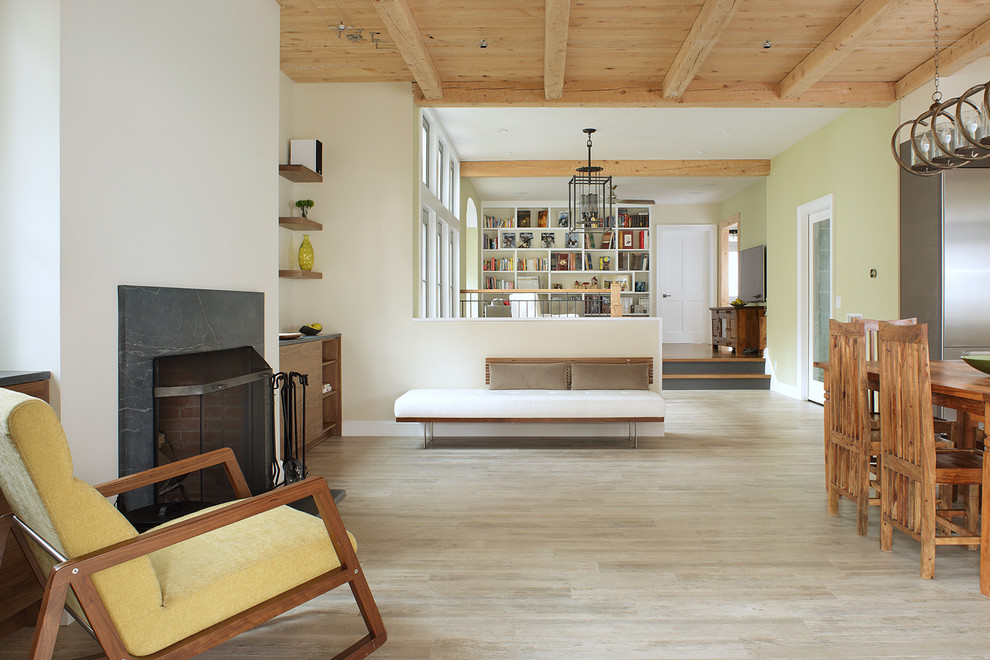 Modelo de sala de estar abierta minimalista de tamaño medio con paredes verdes, suelo de madera clara, todas las chimeneas y marco de chimenea de madera