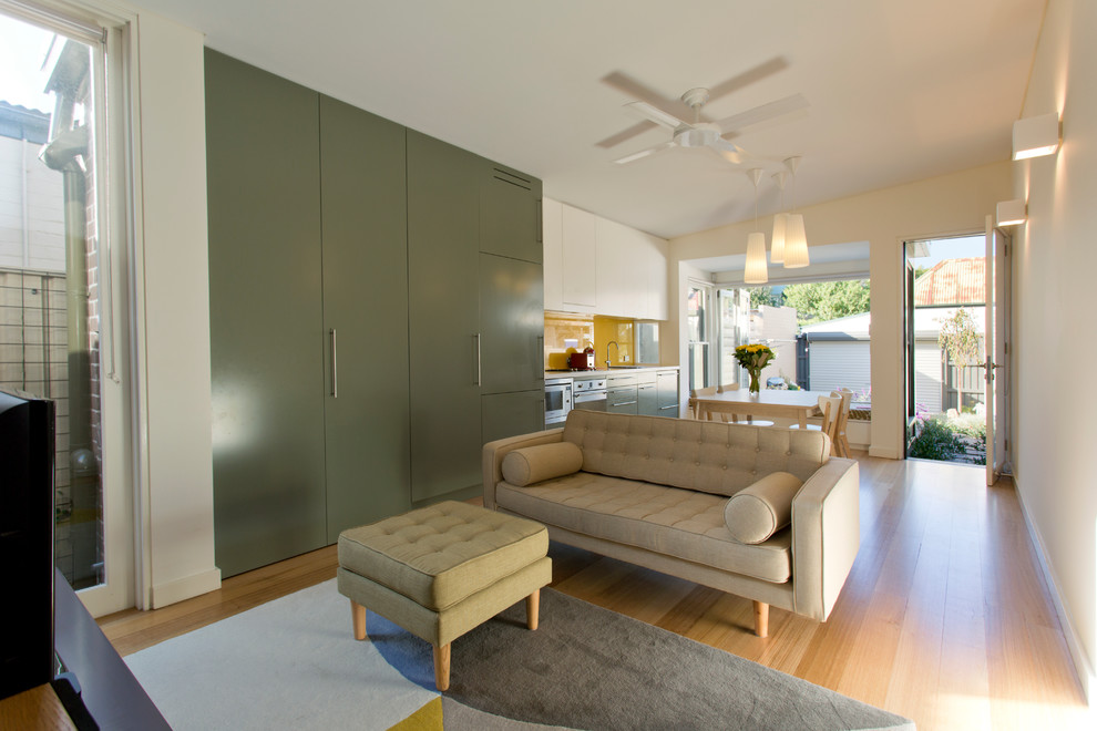 Inspiration pour une petite salle de séjour design ouverte avec un mur beige, parquet clair, aucune cheminée et un téléviseur indépendant.