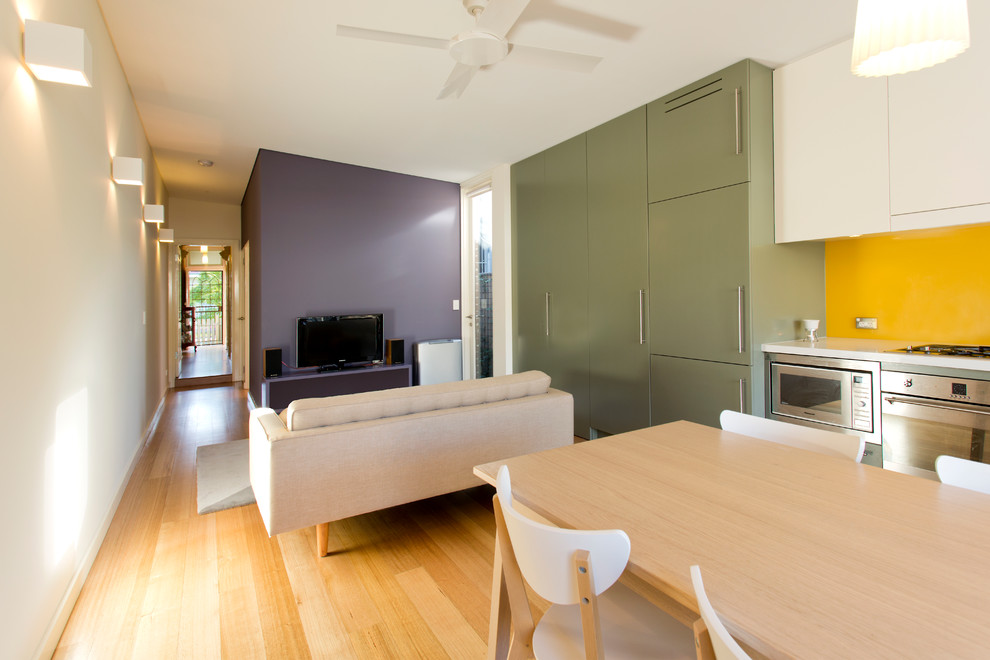 Offenes, Kleines Modernes Wohnzimmer ohne Kamin mit freistehendem TV, beiger Wandfarbe und hellem Holzboden in Sydney