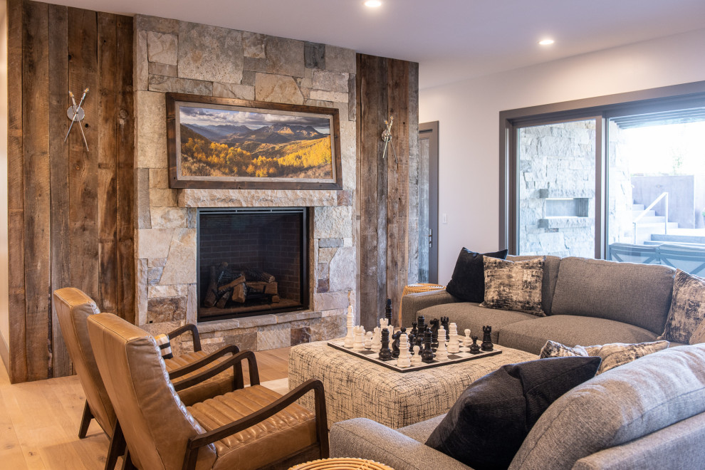 Mittelgroßes, Fernseherloses Modernes Wohnzimmer mit weißer Wandfarbe, braunem Holzboden, Kamin, Kaminumrandung aus Stein und beigem Boden in Salt Lake City