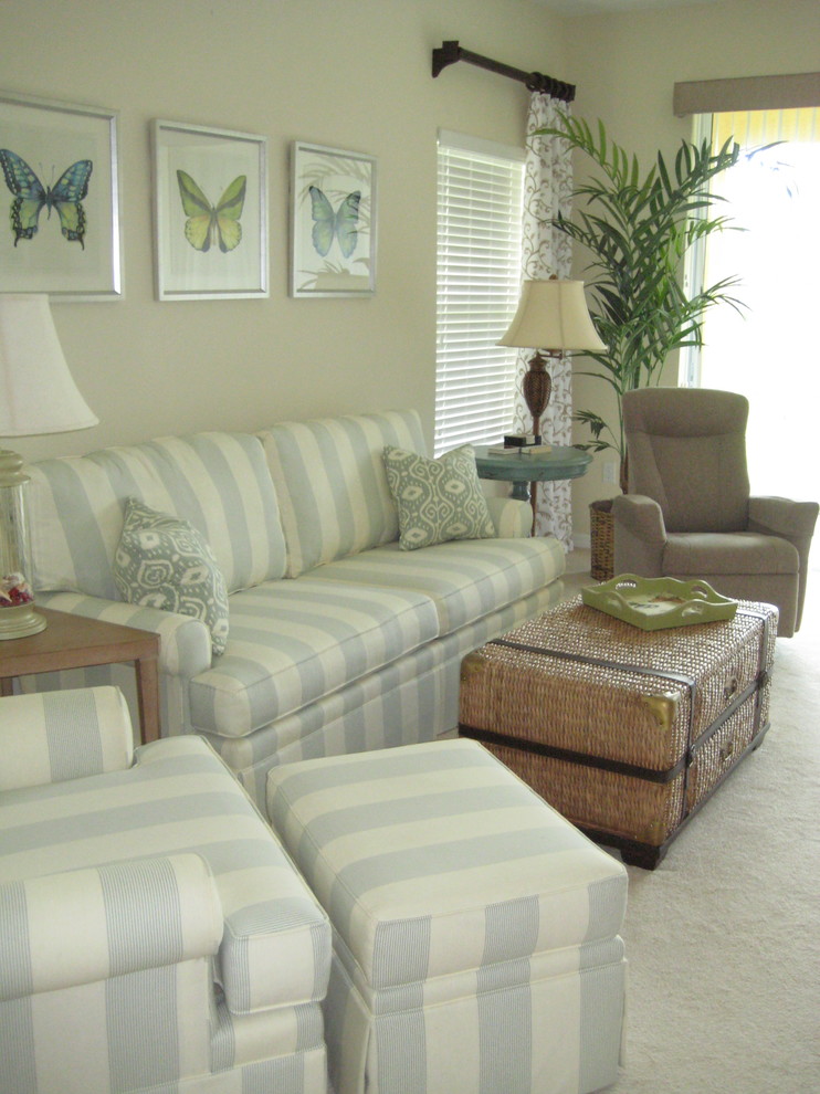 Ejemplo de sala de estar abierta costera pequeña con paredes beige, moqueta y televisor colgado en la pared