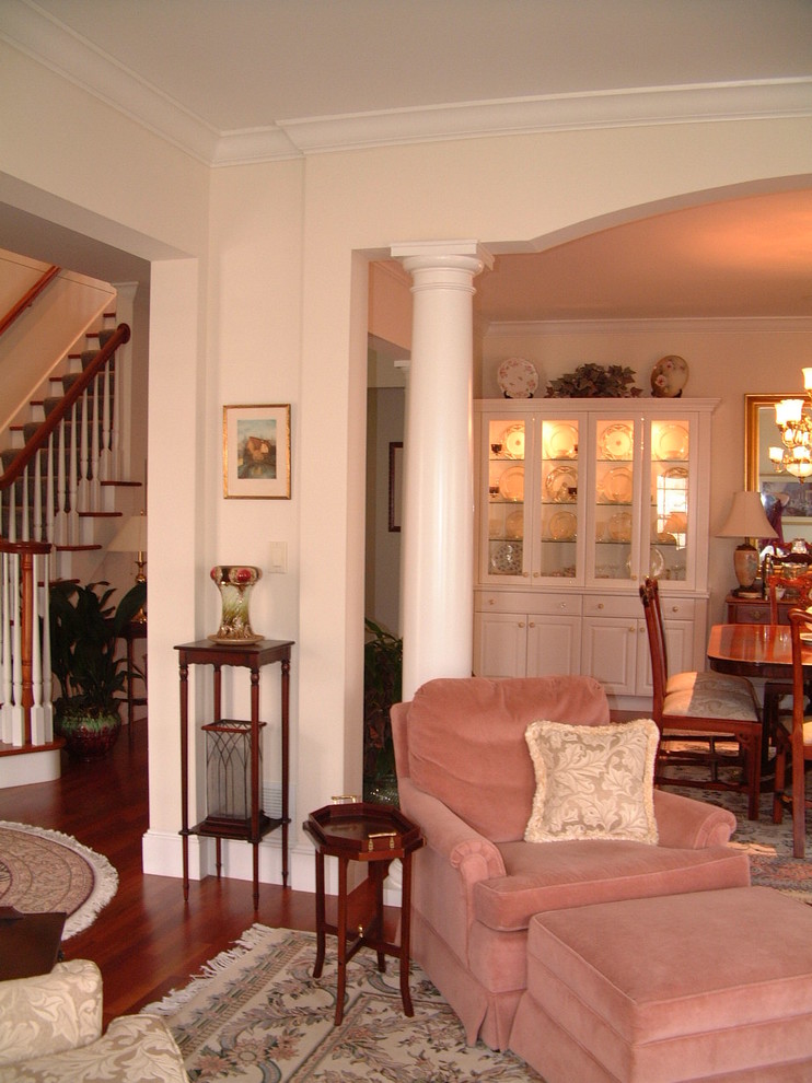 Mittelgroßes, Offenes Klassisches Wohnzimmer mit rosa Wandfarbe und braunem Holzboden in Sonstige