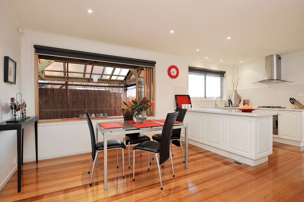 Mid-sized minimalist open concept medium tone wood floor family room photo in Melbourne with white walls