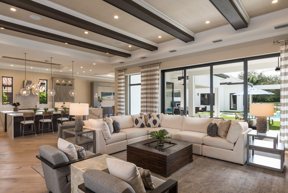 Geräumiges, Offenes Klassisches Wohnzimmer ohne Kamin mit beiger Wandfarbe, hellem Holzboden und TV-Wand in Miami