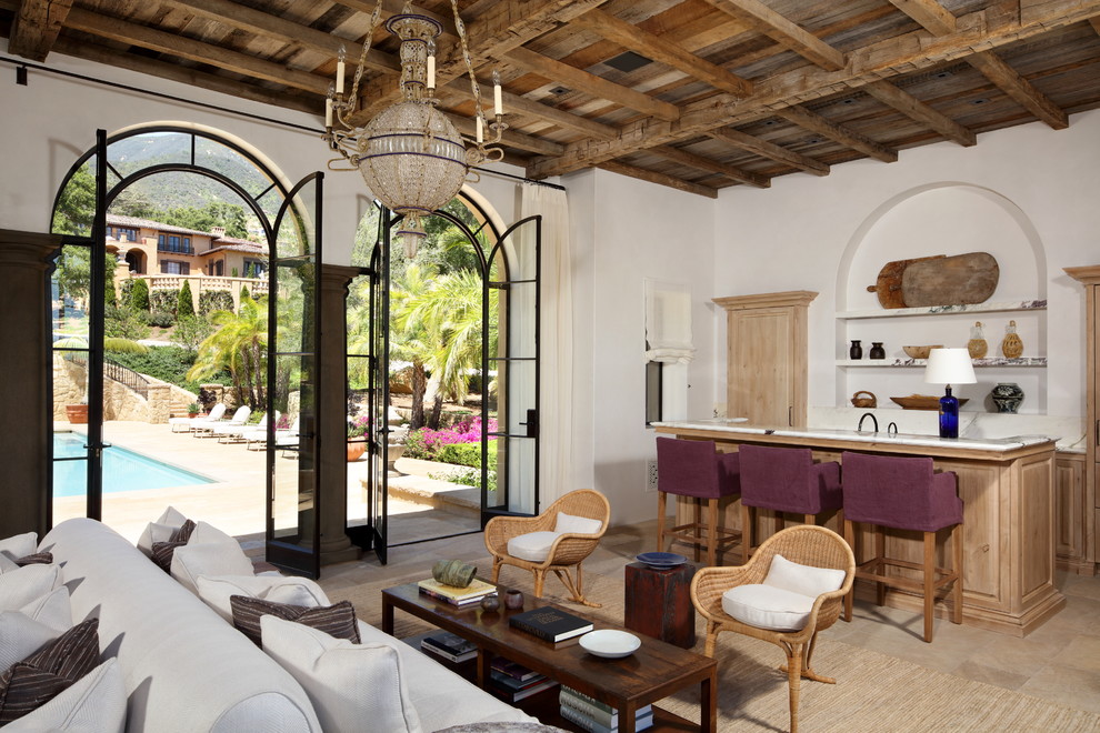 Réalisation d'une salle de séjour méditerranéenne avec un bar de salon, un mur blanc et un sol beige.