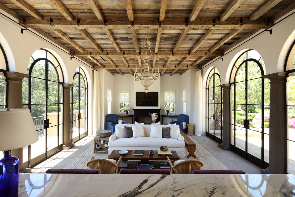 Foto de sala de estar mediterránea con paredes blancas, todas las chimeneas, televisor colgado en la pared y alfombra