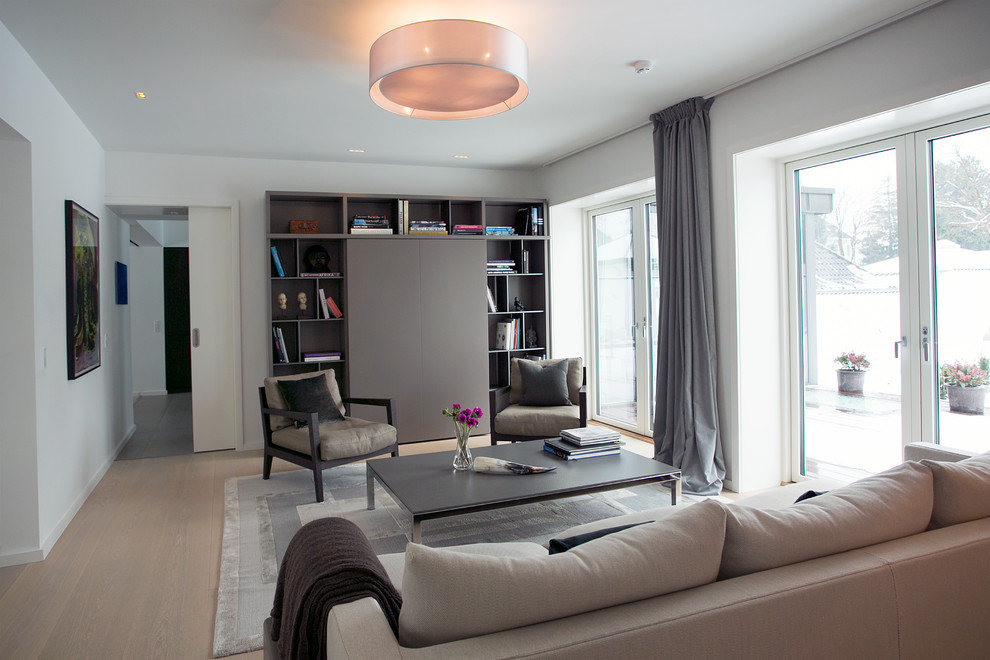 Идея дизайна: парадная, открытая гостиная комната среднего размера в скандинавском стиле с серыми стенами, паркетным полом среднего тона и скрытым телевизором