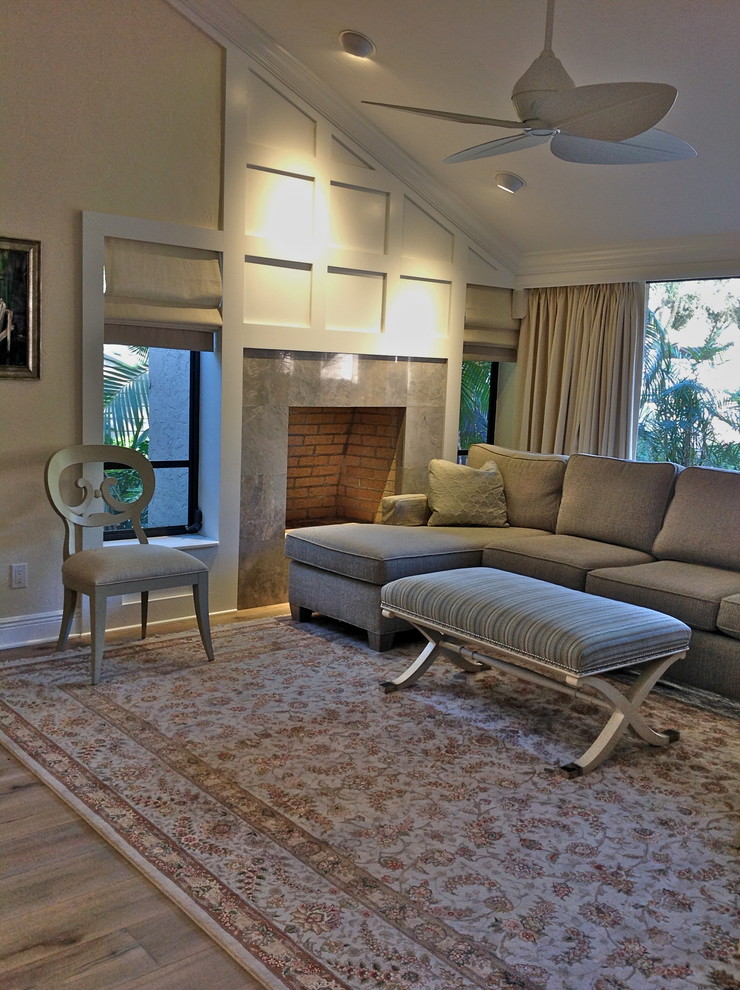 На фото: открытая гостиная комната среднего размера в современном стиле с желтыми стенами, светлым паркетным полом, стандартным камином и фасадом камина из камня с