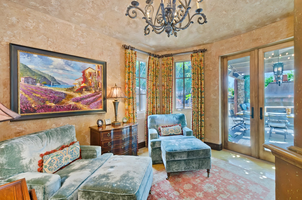 Example of a mid-sized tuscan enclosed limestone floor family room library design in San Diego with beige walls, no fireplace and a concealed tv