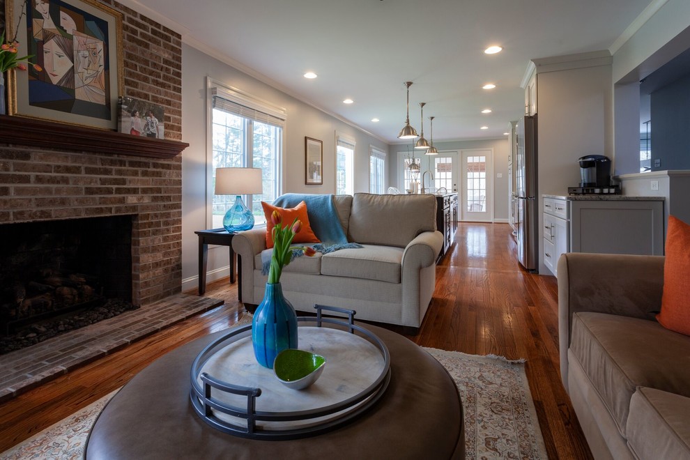 Mittelgroßes Klassisches Wohnzimmer mit grauer Wandfarbe, braunem Holzboden, Kamin, Kaminumrandung aus Backstein und braunem Boden in Philadelphia
