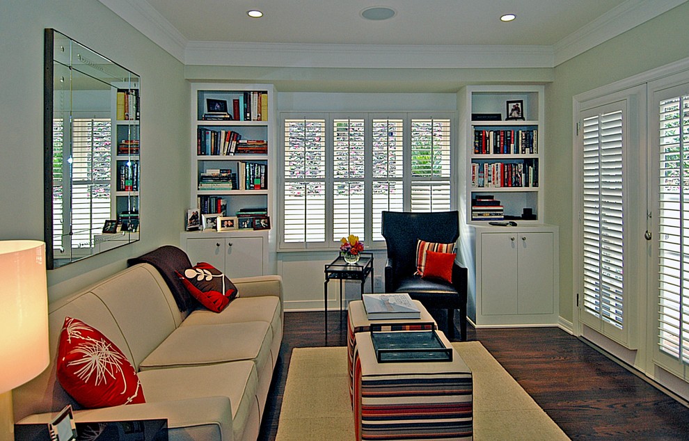 Ejemplo de sala de estar con biblioteca cerrada clásica renovada de tamaño medio sin chimenea y televisor con suelo de madera oscura y paredes verdes