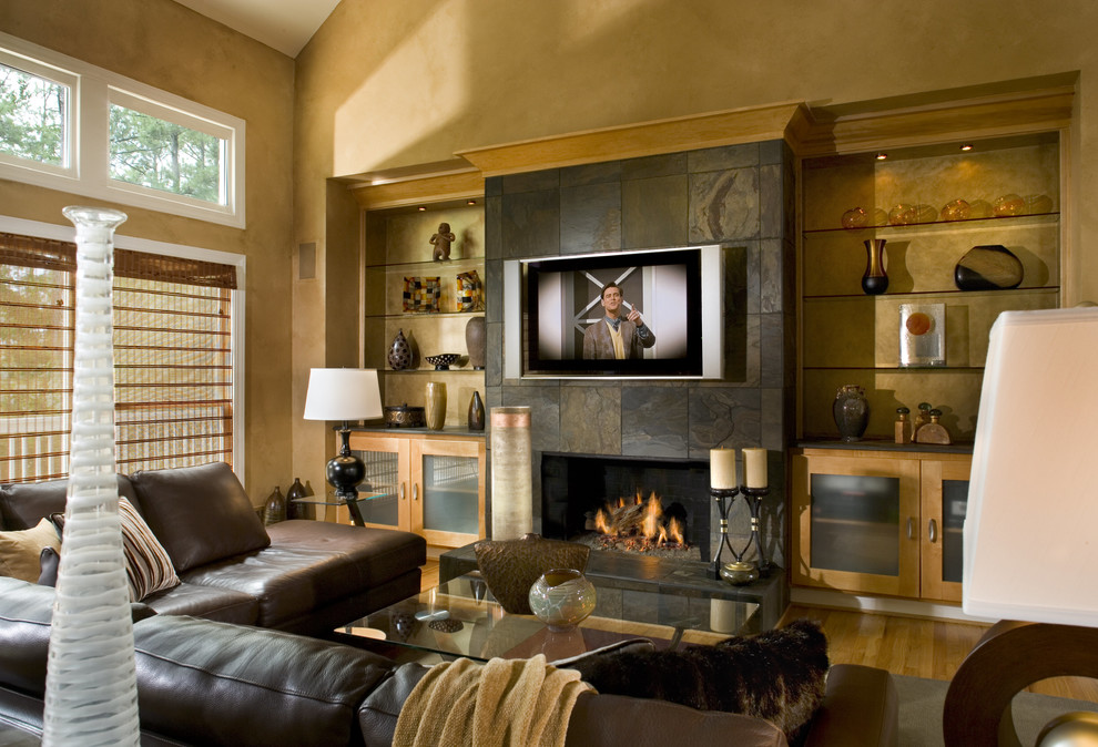 Ejemplo de sala de estar abierta tradicional renovada grande con paredes amarillas, suelo de madera en tonos medios, todas las chimeneas, marco de chimenea de piedra, televisor colgado en la pared y suelo beige