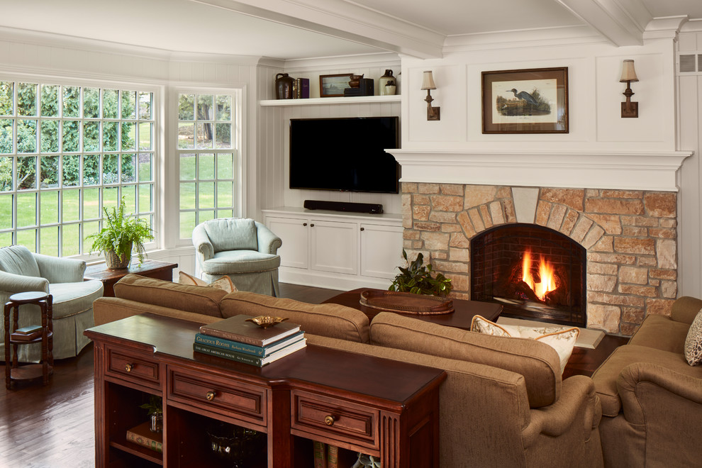 Ejemplo de sala de estar tradicional con paredes blancas, suelo de madera oscura, todas las chimeneas, marco de chimenea de piedra y pared multimedia