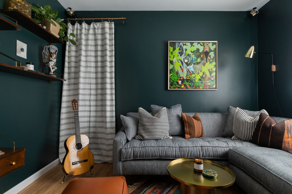 Cette image montre une salle de séjour design avec un mur vert, un sol en bois brun et un sol marron.