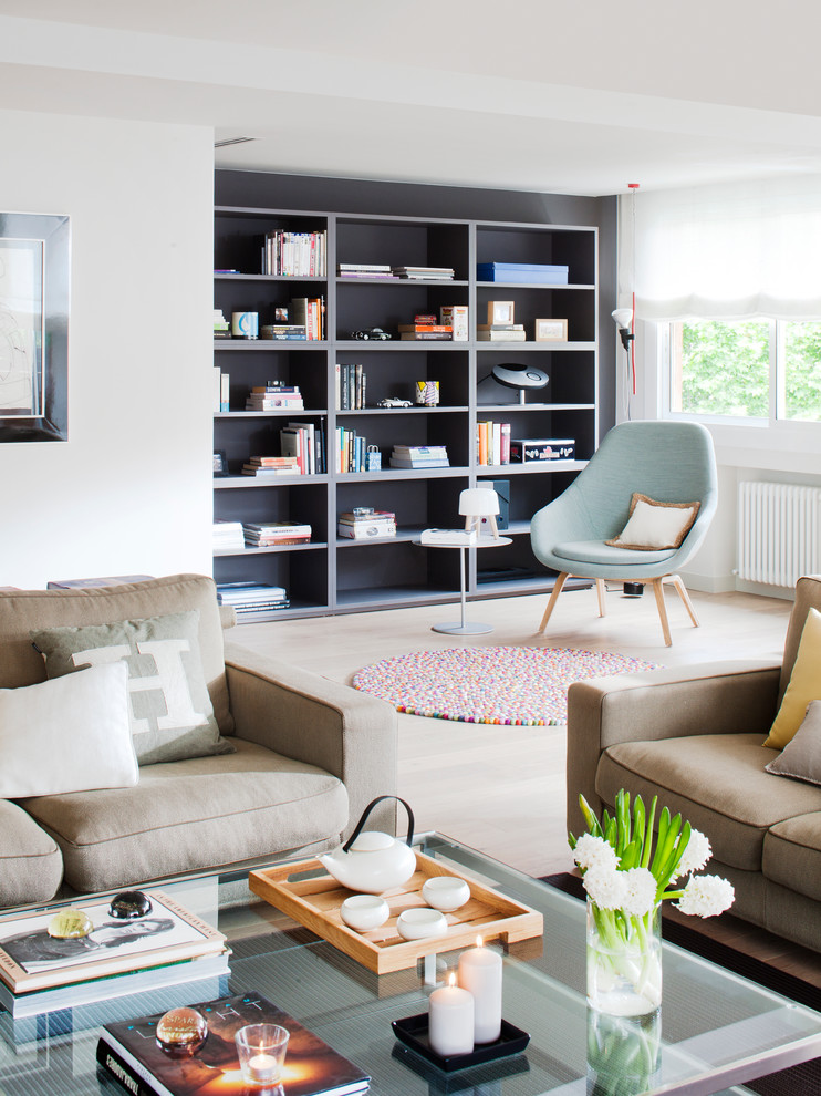 Пример оригинального дизайна: открытая гостиная комната среднего размера в современном стиле с с книжными шкафами и полками, белыми стенами и светлым паркетным полом без камина, телевизора