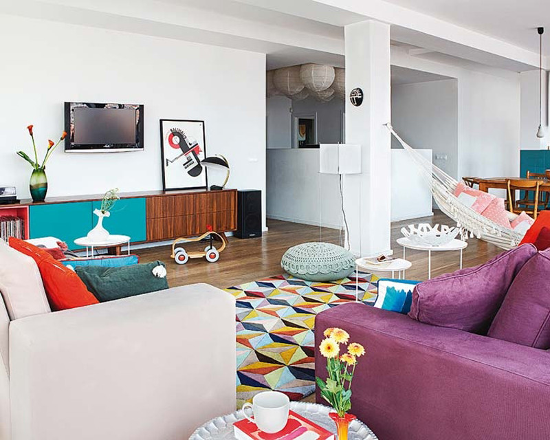 Ejemplo de sala de estar abierta bohemia grande sin chimenea con paredes blancas, suelo de madera oscura y televisor colgado en la pared