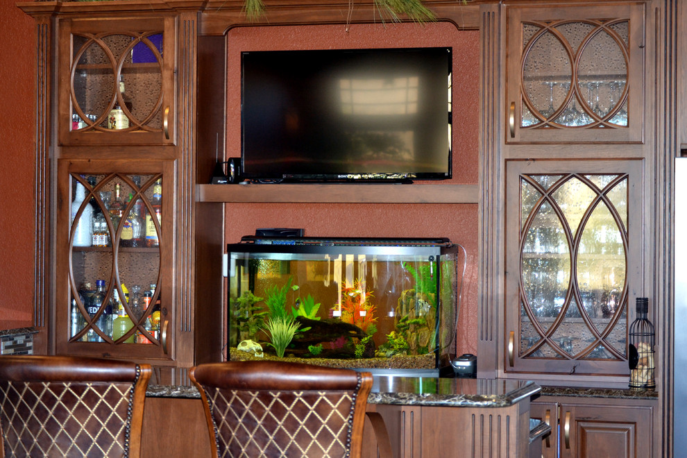 Imagen de sala de estar con barra de bar tradicional grande con suelo de madera oscura y televisor independiente
