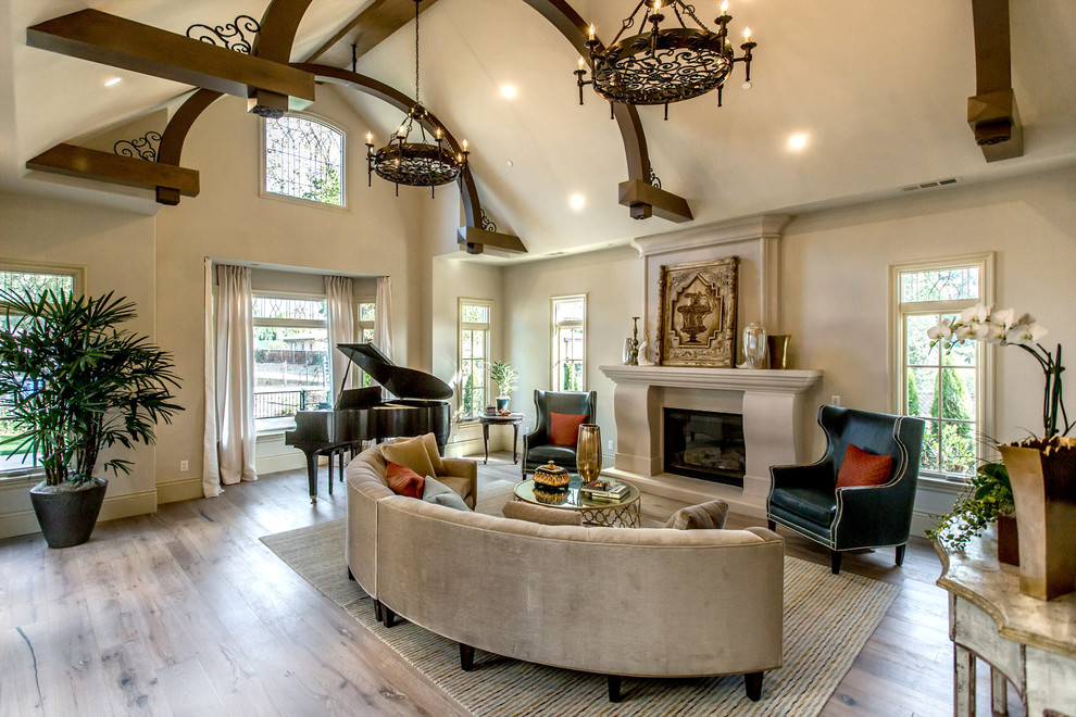 Inspiration for a mediterranean medium tone wood floor and brown floor family room remodel in Los Angeles with beige walls and a standard fireplace