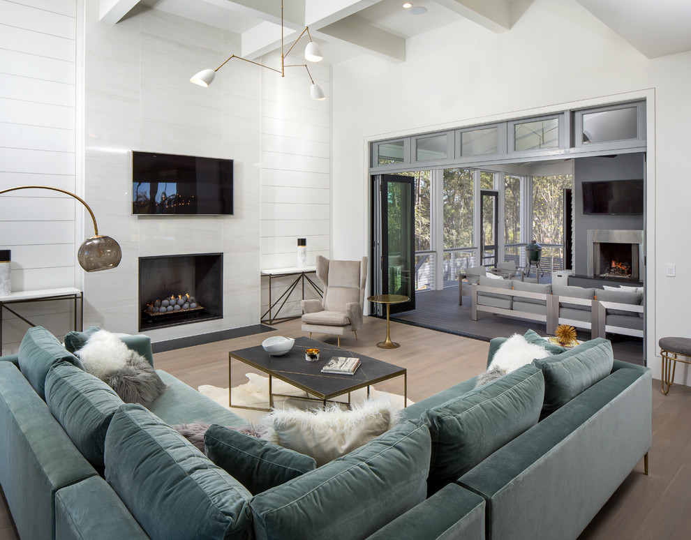 Cette photo montre une grande salle de séjour tendance ouverte avec un mur blanc, un sol en bois brun, une cheminée standard, un manteau de cheminée en métal et un sol gris.
