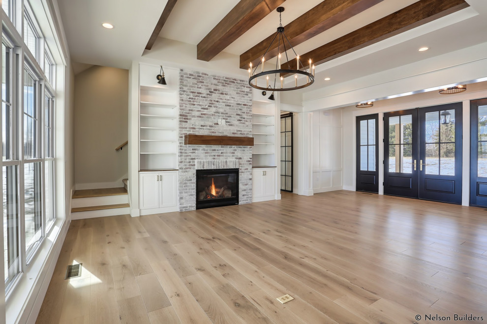 Family room - mid-sized farmhouse open concept light wood floor, brown floor, exposed beam and wall paneling family room idea in Chicago with white walls, a standard fireplace, a brick fireplace and no tv