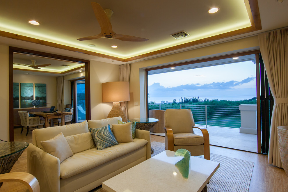 Idee per un piccolo soggiorno tropicale aperto con pareti beige, pavimento in legno massello medio, parete attrezzata e pavimento marrone