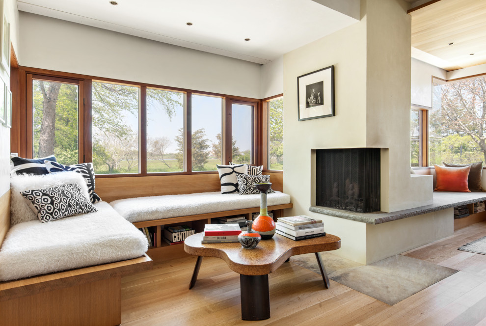 Diseño de sala de estar abierta contemporánea con paredes beige, suelo de madera en tonos medios, todas las chimeneas y suelo marrón