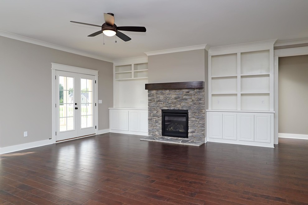 Inspiration for a large classic open plan games room in Raleigh with grey walls, a standard fireplace, a stone fireplace surround, brown floors and vinyl flooring.
