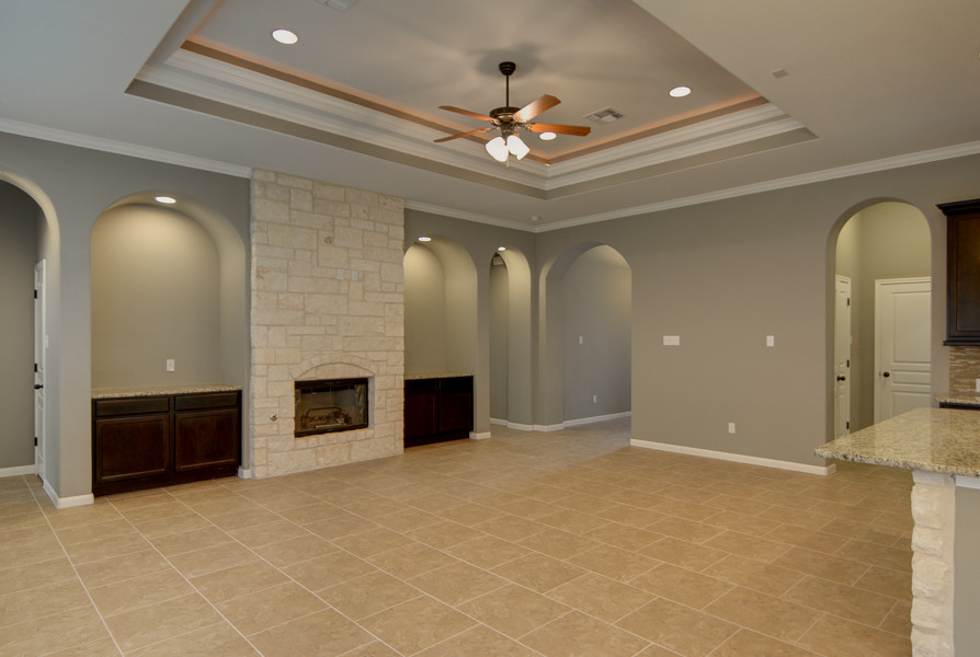 Cette photo montre une grande salle de séjour craftsman ouverte avec un sol en carrelage de céramique, une cheminée standard et un manteau de cheminée en pierre.