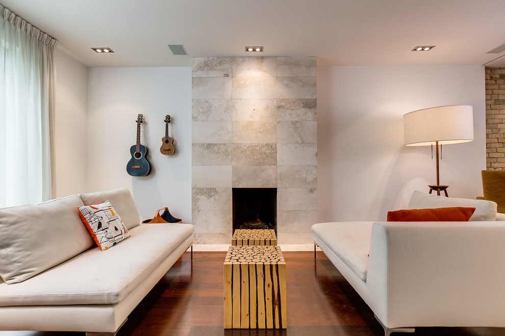 Cette image montre une salle de séjour design avec un manteau de cheminée en carrelage.