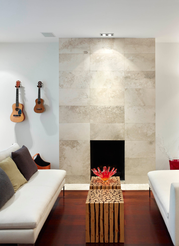 Foto di un piccolo soggiorno minimalista aperto con pareti bianche, parquet scuro, camino classico, cornice del camino in pietra e nessuna TV