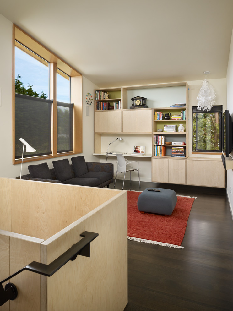 Пример оригинального дизайна: двухуровневая гостиная комната в стиле модернизм с бежевыми стенами, темным паркетным полом, телевизором на стене, коричневым полом и ковром на полу
