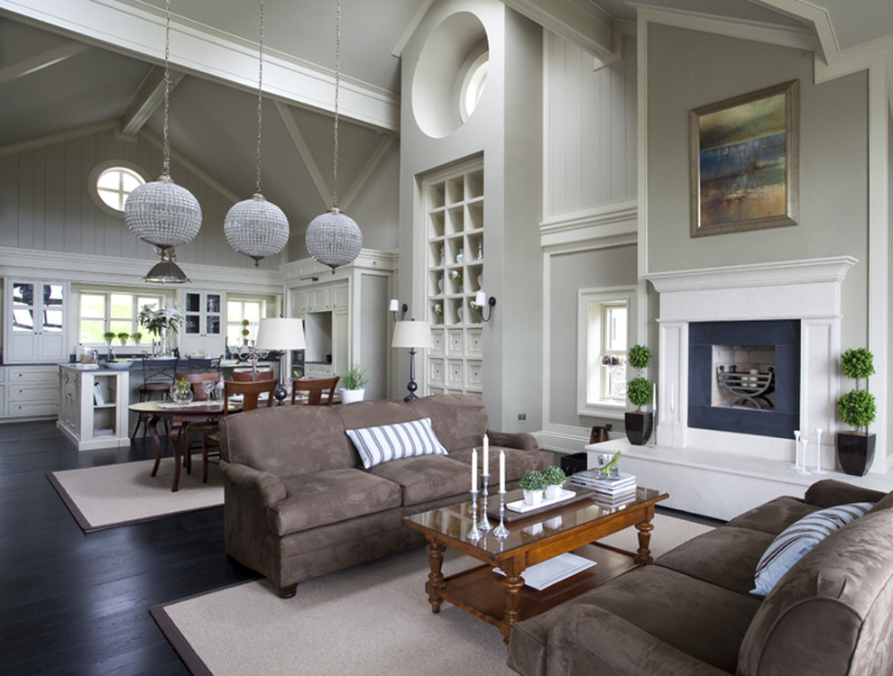 Идея дизайна: огромная открытая гостиная комната в классическом стиле с серыми стенами, темным паркетным полом, стандартным камином и фасадом камина из дерева