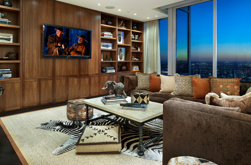Diseño de sala de estar de estilo americano de tamaño medio sin chimenea con paredes marrones, suelo de madera oscura, televisor colgado en la pared y suelo marrón