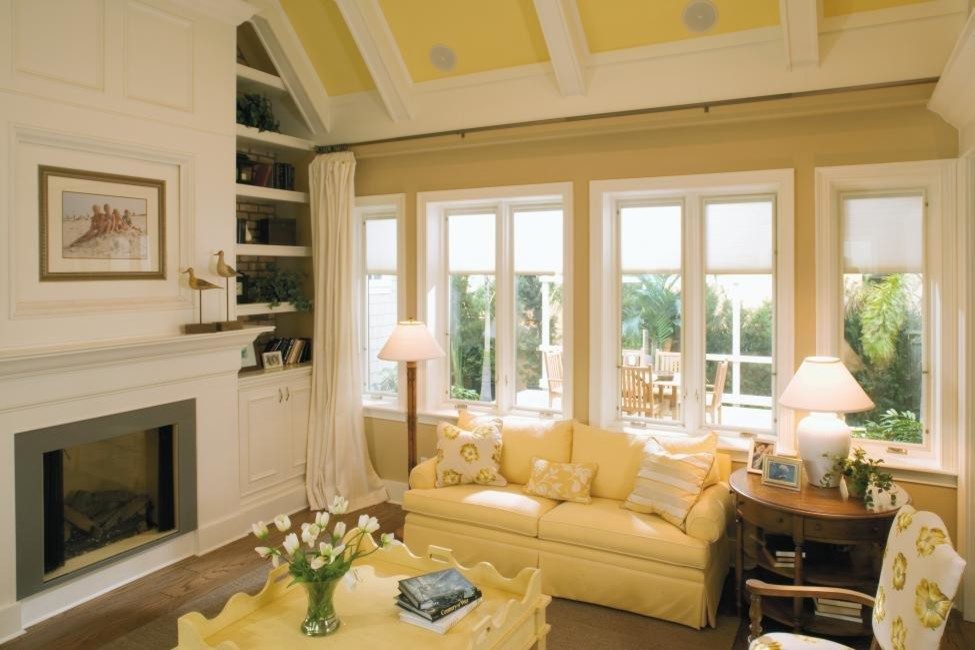 Beach style enclosed games room in San Francisco with yellow walls, a standard fireplace and a wooden fireplace surround.