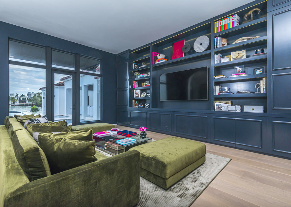 Immagine di un ampio soggiorno minimalista aperto con libreria, pareti blu, pavimento in legno massello medio, parete attrezzata, pavimento marrone e pannellatura