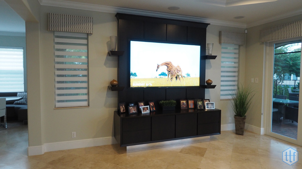 Imagen de sala de estar abierta actual de tamaño medio sin chimenea con paredes beige y pared multimedia