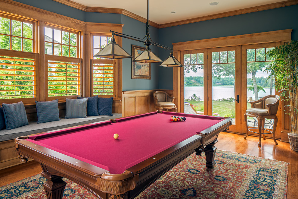 Diseño de sala de juegos en casa clásica con paredes azules, suelo de madera en tonos medios y suelo marrón